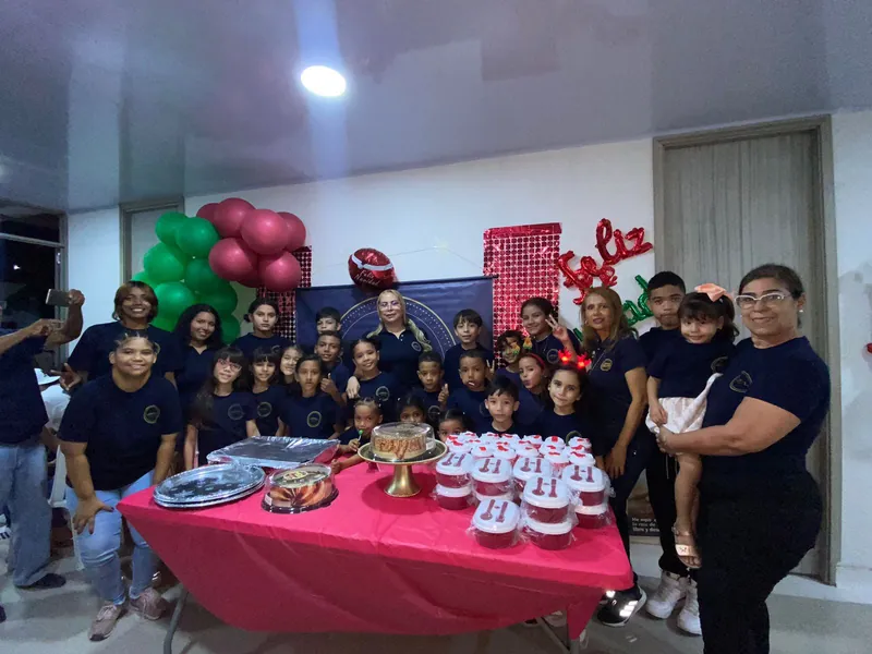 Niños y voluntarios junto a la mesa de una fiesta