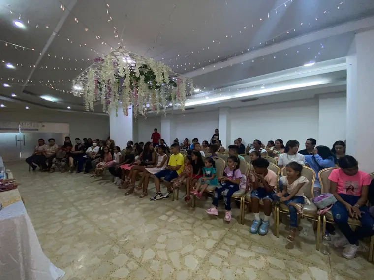 Salón lleno de niños y familias en una celebración