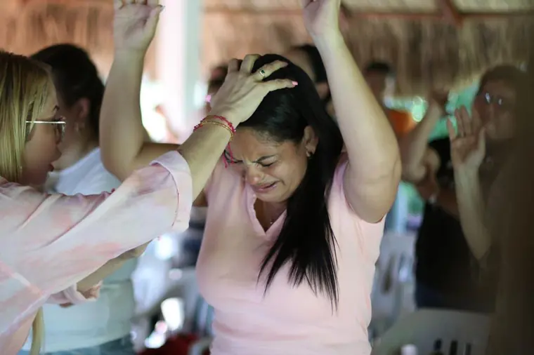 Mujer en oración profunda con los brazos en alto
